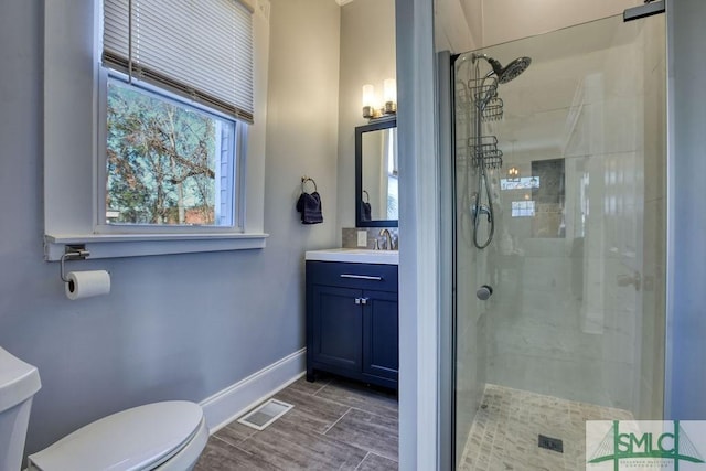 bathroom with toilet, a shower with shower door, and vanity