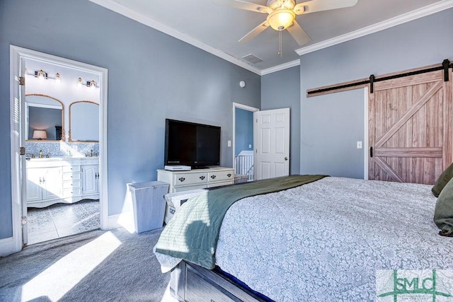 bedroom featuring a barn door, crown molding, carpet floors, ceiling fan, and ensuite bathroom