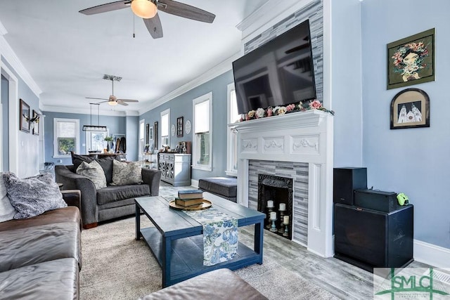 living room with a fireplace, light wood-type flooring, ceiling fan, and ornamental molding