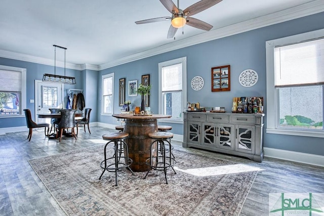 dining space featuring hardwood / wood-style floors, ceiling fan, and ornamental molding