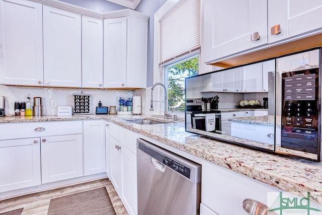 kitchen featuring stainless steel appliances, white cabinets, sink, and backsplash