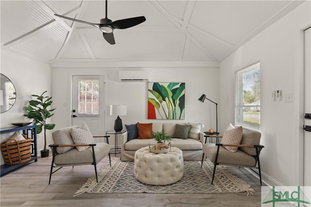 living area featuring ceiling fan, a wall mounted AC, and light hardwood / wood-style flooring