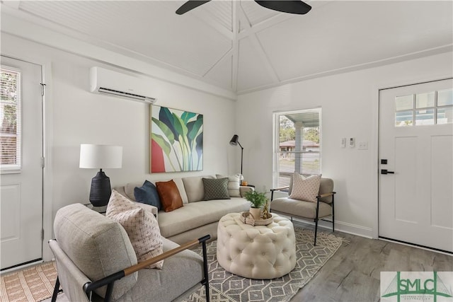 living room with ceiling fan, a wall mounted AC, hardwood / wood-style floors, and vaulted ceiling