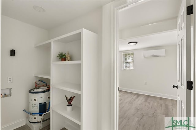 corridor featuring light hardwood / wood-style floors, electric water heater, and a wall unit AC