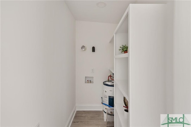 laundry area with water heater, light wood-type flooring, and hookup for a washing machine