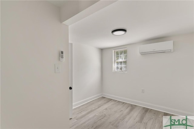 empty room with a wall unit AC and light hardwood / wood-style flooring