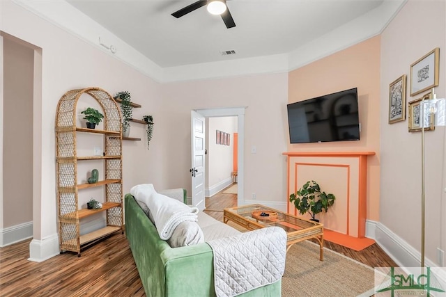 living room featuring dark hardwood / wood-style flooring and ceiling fan