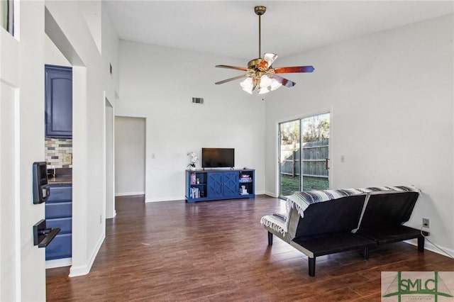 living room featuring dark wood-type flooring, high vaulted ceiling, and ceiling fan