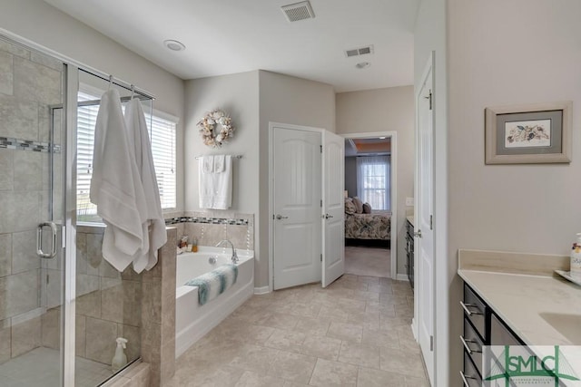 bathroom with independent shower and bath, vanity, and plenty of natural light