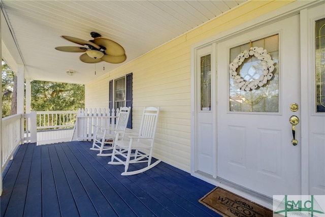 wooden terrace featuring covered porch and ceiling fan