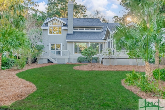 rear view of property featuring a wooden deck and a yard