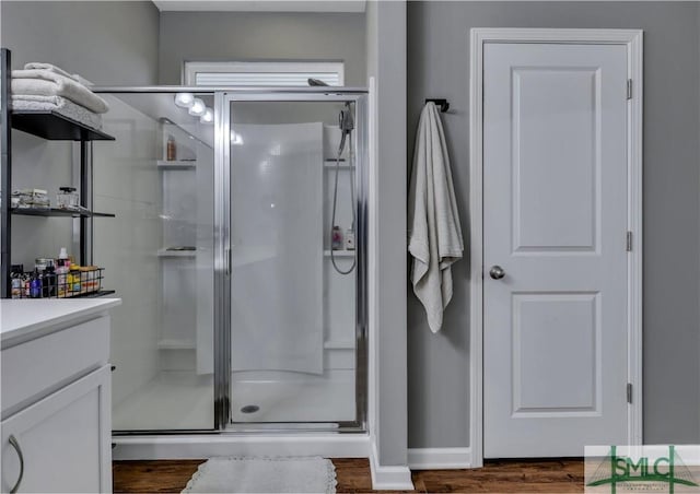 bathroom featuring a shower with door, vanity, and hardwood / wood-style flooring