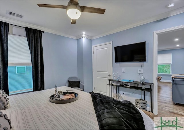 bedroom with ceiling fan, ornamental molding, and light hardwood / wood-style flooring