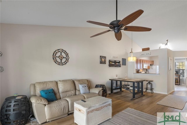 living room with high vaulted ceiling, hardwood / wood-style floors, and ceiling fan