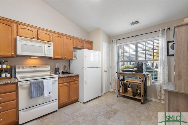 kitchen with white appliances, light stone countertops, and lofted ceiling