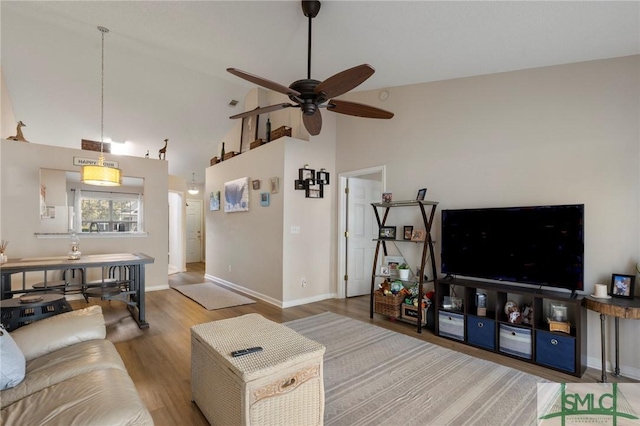 living room featuring ceiling fan, high vaulted ceiling, and wood-type flooring