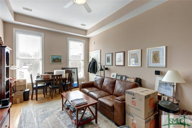 living room featuring ceiling fan, light hardwood / wood-style floors, and plenty of natural light