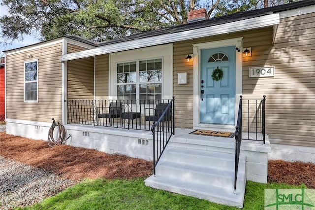 view of exterior entry with a porch