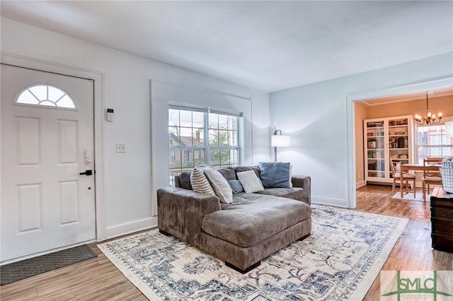 living room featuring hardwood / wood-style flooring, built in shelves, and a chandelier