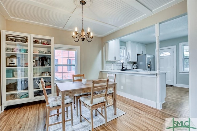 dining space featuring light hardwood / wood-style flooring and a chandelier