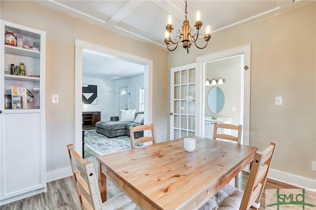 dining space with an inviting chandelier and light hardwood / wood-style floors