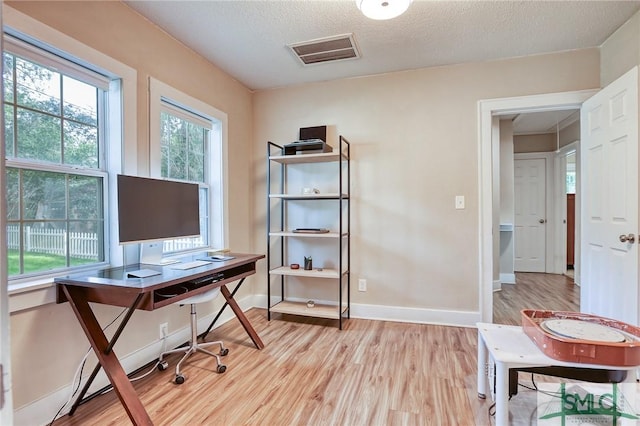 office space with a textured ceiling and light wood-type flooring