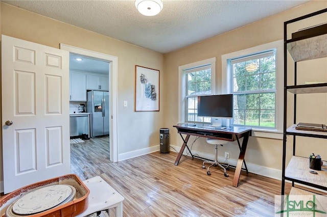 office with a textured ceiling and light hardwood / wood-style floors