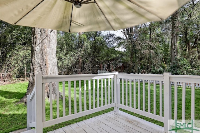 wooden deck with ceiling fan and a yard