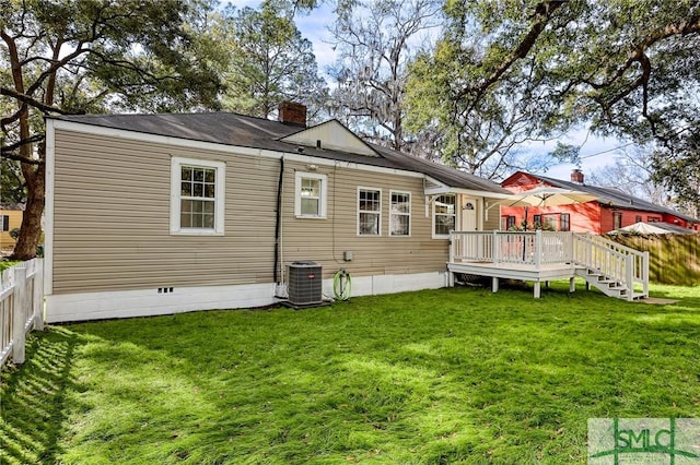 back of property with a yard, a deck, and central AC unit