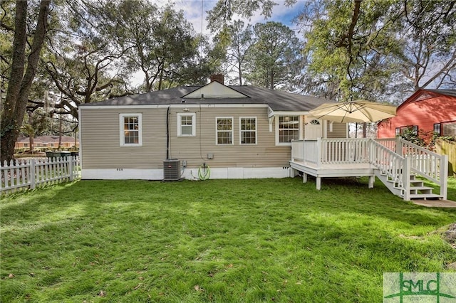 back of property with a lawn, central air condition unit, and a wooden deck