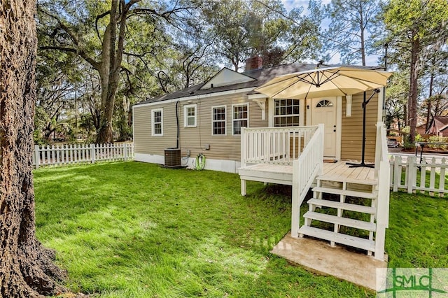 rear view of house featuring a deck and a yard