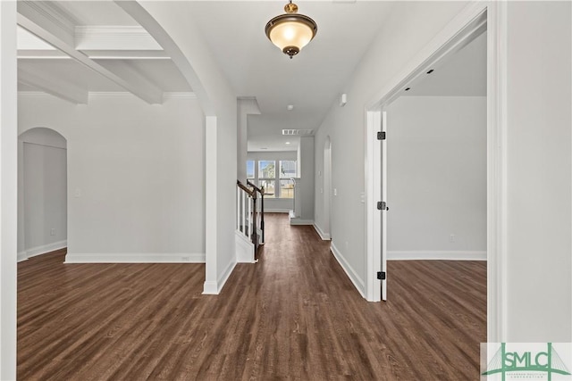 foyer entrance featuring visible vents, baseboards, stairway, dark wood-style floors, and arched walkways