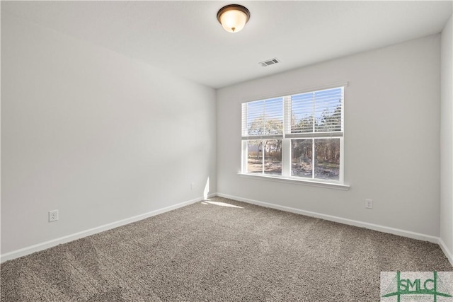 carpeted spare room featuring visible vents and baseboards