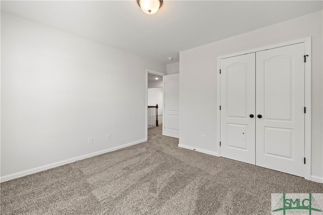 unfurnished bedroom featuring a closet, baseboards, and carpet