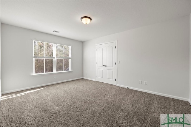 carpeted empty room featuring visible vents and baseboards