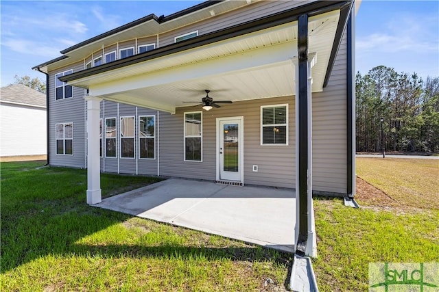 rear view of property featuring a patio area, a yard, and a ceiling fan