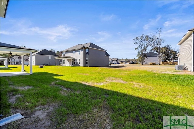 view of yard featuring a residential view and central AC unit