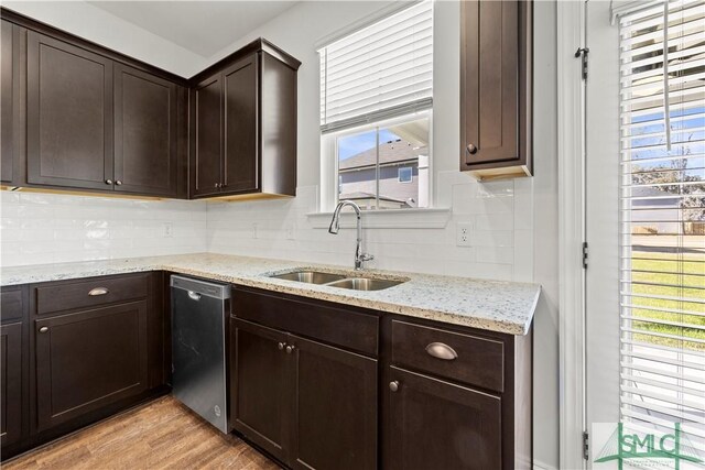 kitchen with a sink, dark brown cabinetry, light wood-style floors, dishwasher, and tasteful backsplash