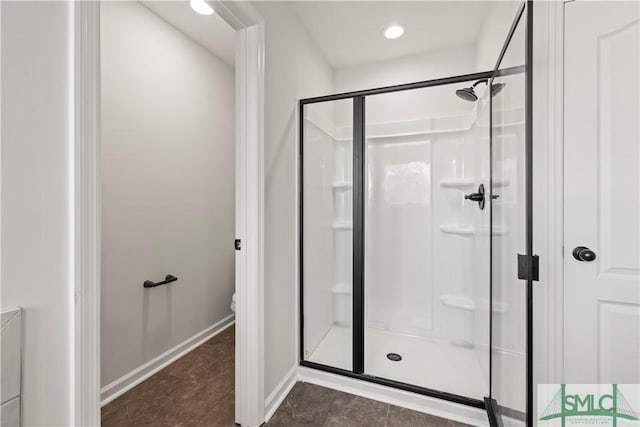 bathroom featuring tile patterned floors, baseboards, toilet, and a stall shower