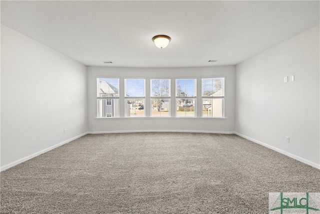 spare room with baseboards and carpet floors