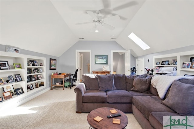 living room with light colored carpet, built in features, ceiling fan, and vaulted ceiling with skylight