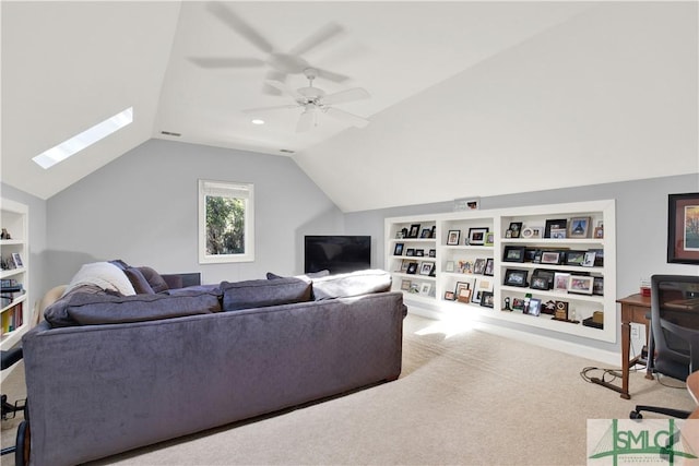 carpeted living room featuring built in shelves, ceiling fan, and vaulted ceiling with skylight