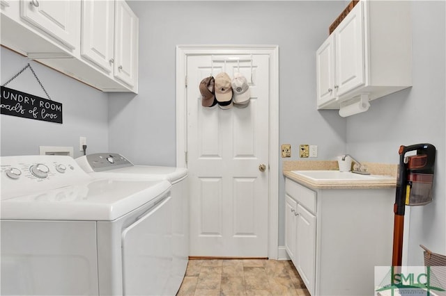 laundry area with separate washer and dryer, cabinets, and sink