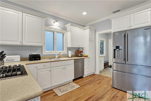 kitchen with stainless steel appliances, crown molding, white cabinets, light hardwood / wood-style flooring, and sink