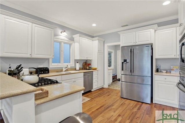 kitchen featuring appliances with stainless steel finishes, white cabinets, and sink