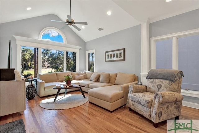 living room with high vaulted ceiling, ceiling fan, and light hardwood / wood-style flooring