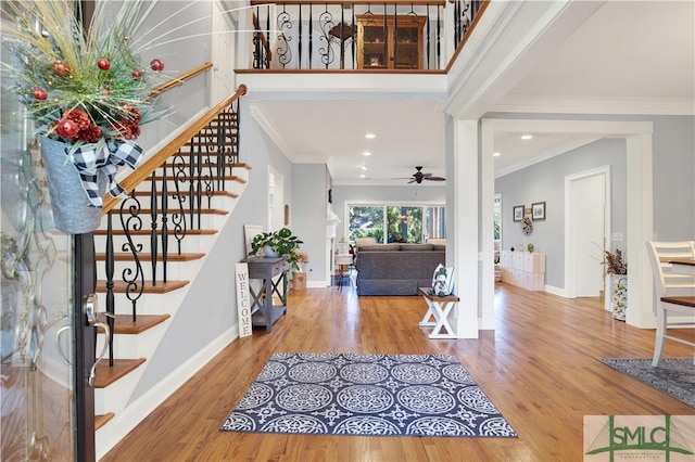 entryway with ceiling fan, crown molding, and hardwood / wood-style floors