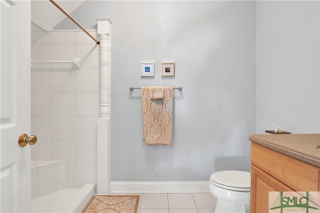 bathroom featuring toilet, a tile shower, tile patterned floors, and vanity