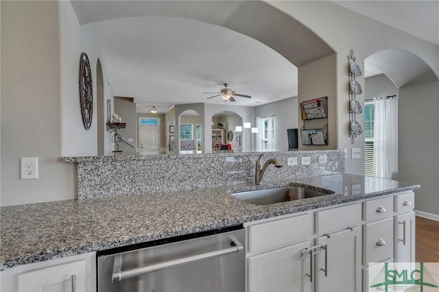 kitchen featuring dishwasher, light stone countertops, ceiling fan, sink, and white cabinetry