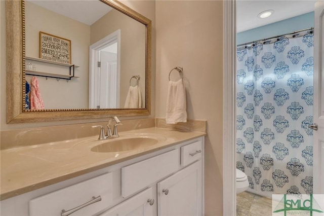 bathroom with curtained shower, vanity, and toilet